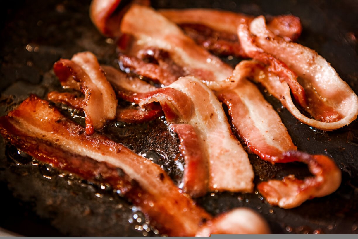 sizzling bacon frying in a pan