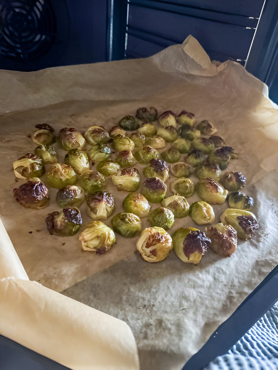 oven roasted brussel sprouts on beige baking paper in metal sheet