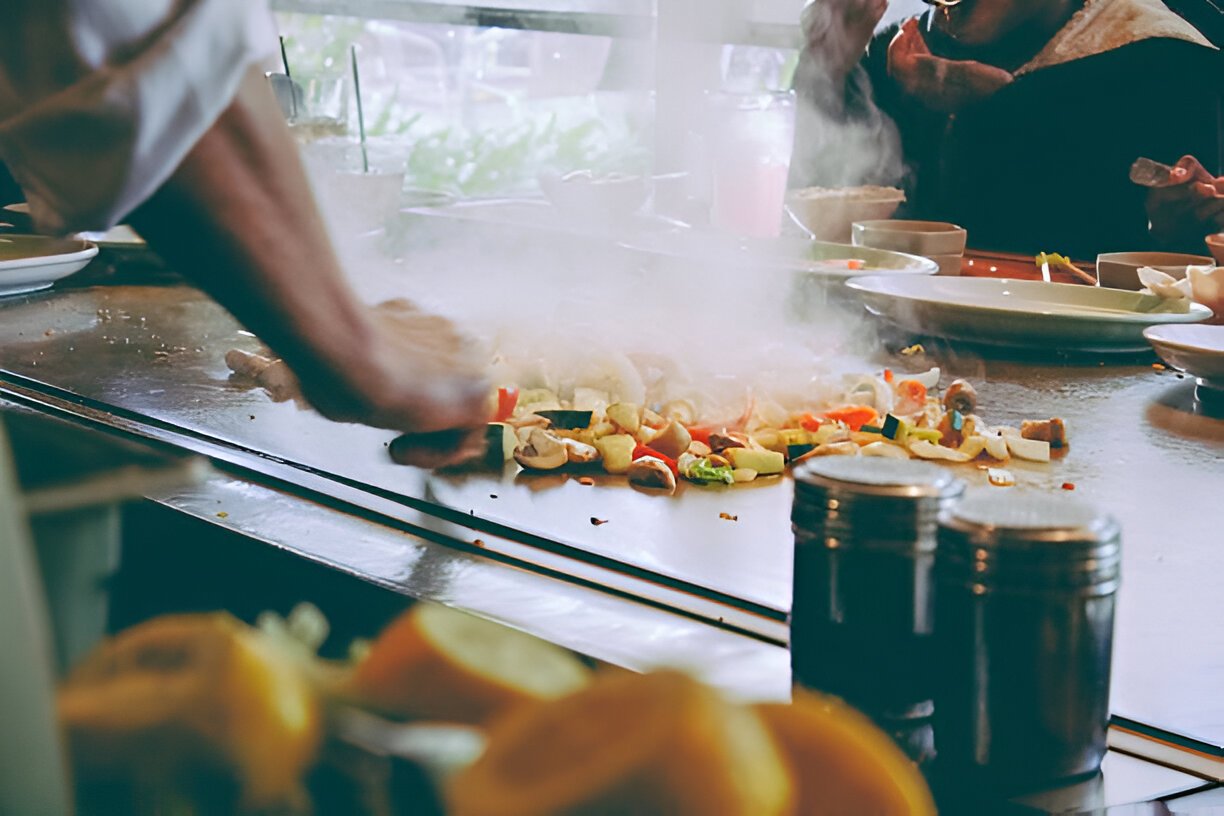 teppanyaki restaurant chef cooking in front of guests