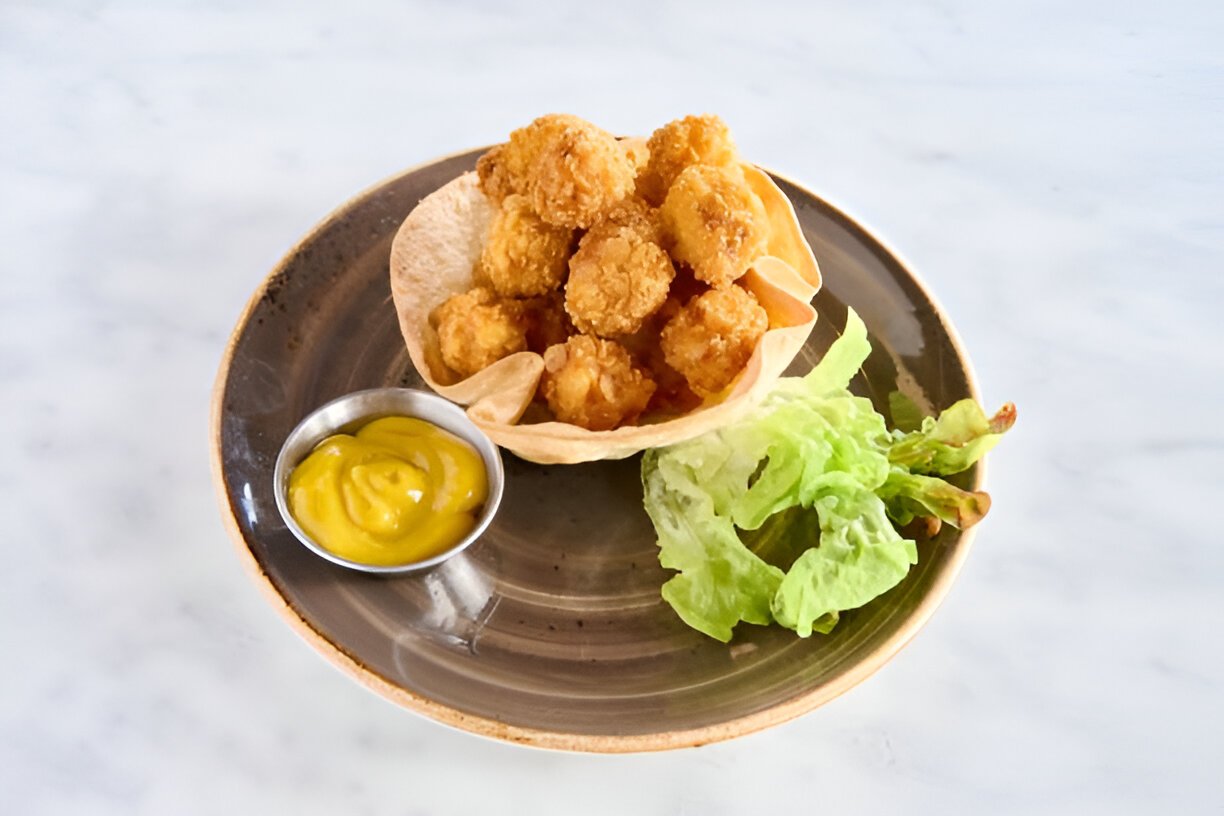 crispy popcorn chicken served with a sauce and lettuce