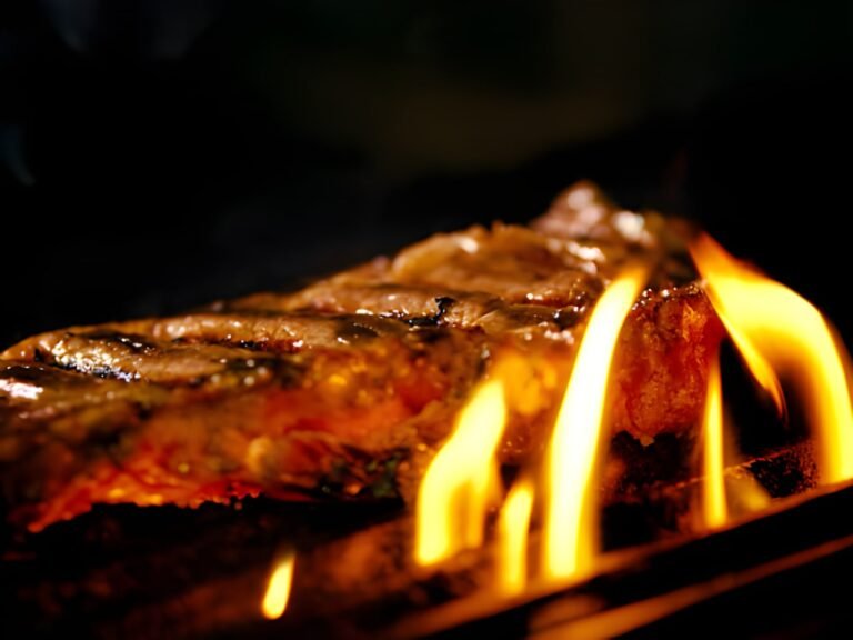 juicy meat steaks on grills flame burning
